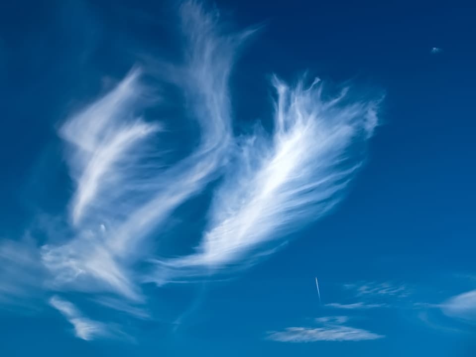 Stahlblauer Himmel mit federartigen, feinen Wolken.