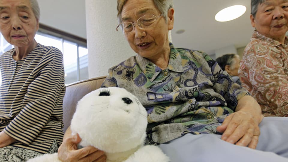 Der Robbenroboter Paro gibt Laute von sich, bewegt sich und ist in japanischen Altersheimen wie hier in Iwaki schon im Einsatz. 