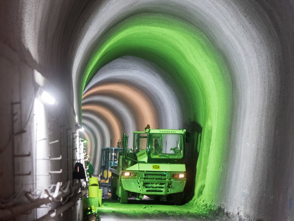 Grünes Licht in einem Tunnel beleuchtet eine Baumaschine