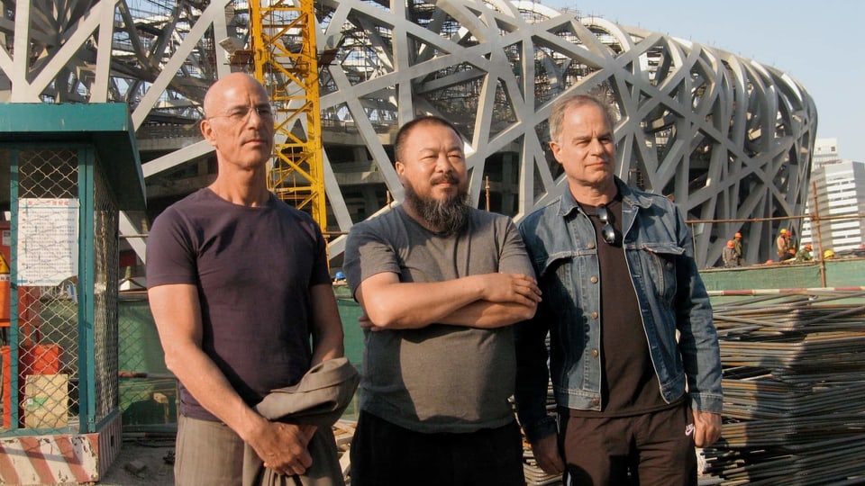 Herzog & De Meuron mit Ai Wei Wei vor einem Gebäude.