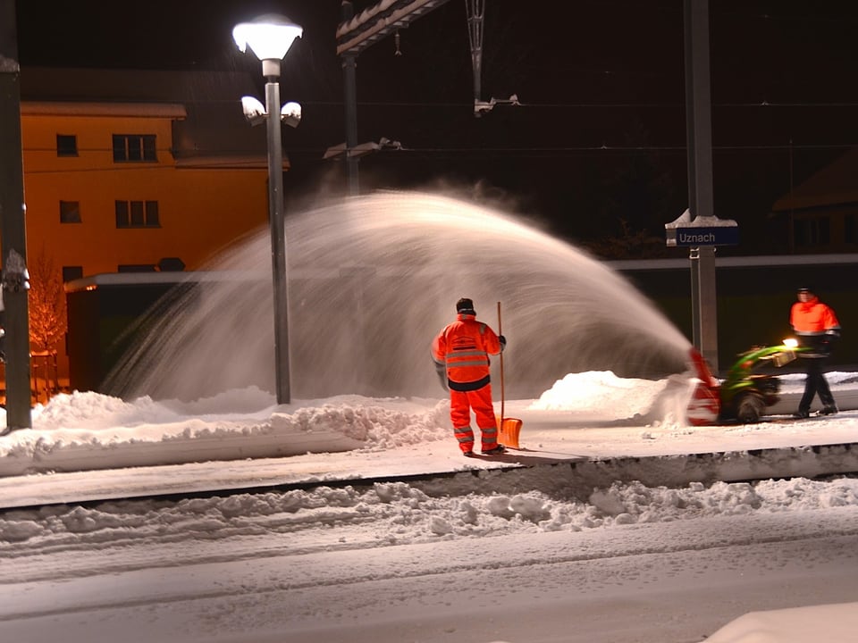 Arbeiter beim Schnee Räumen auf dem Bahnsteig. 