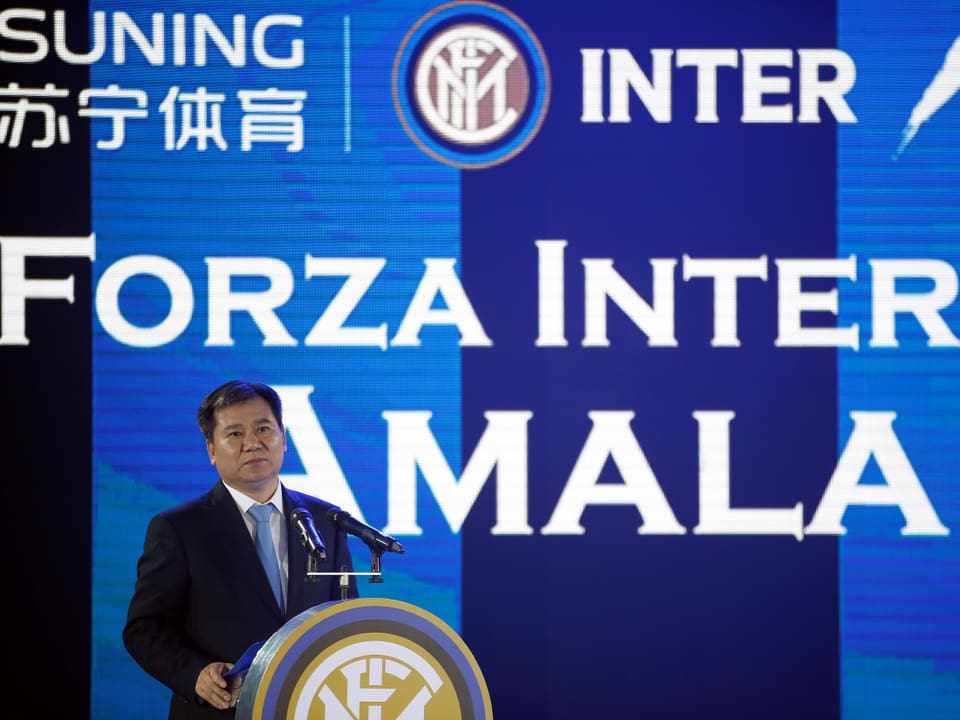 Der Verwaltungsratspräsident von Suning an einem Rednerpult vor einer blauen Wand mit chinesischen Schriftzeichen und der Auftschrift Forza Inter