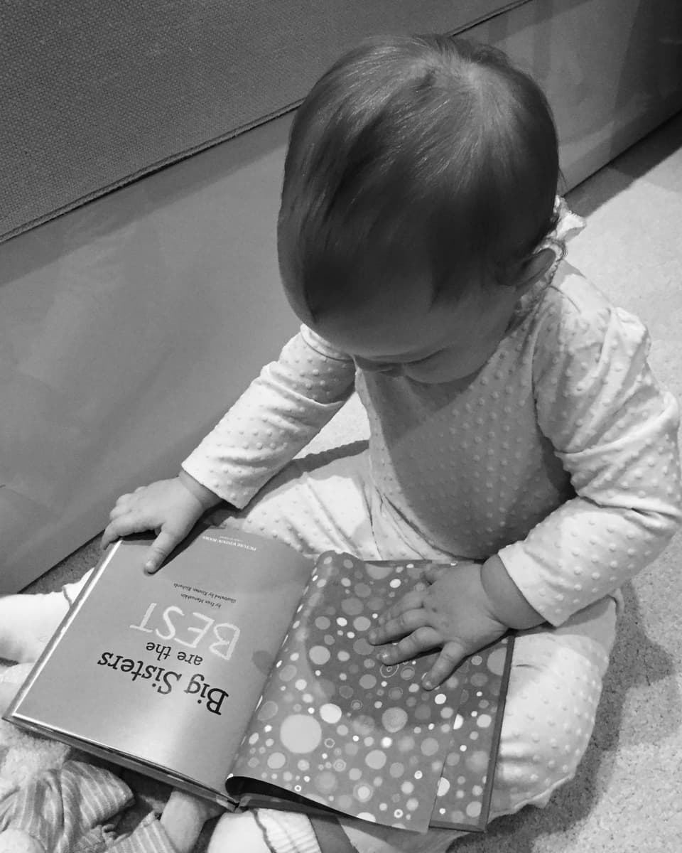 Baby Charlotte schaut ein Buch an