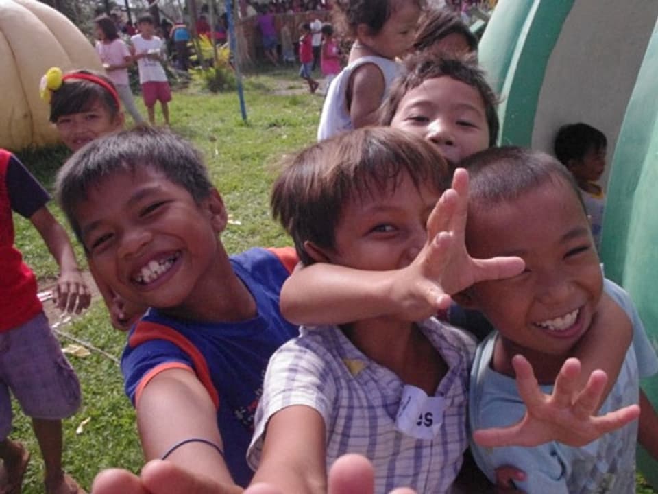 Lachende Kinder posieren vor der Kamera.