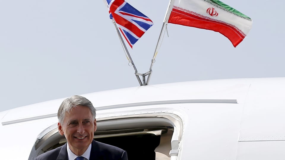 Hammond steigt aus einem Flugzeug, Flaggen von GB und Iran auf dem Dach.
