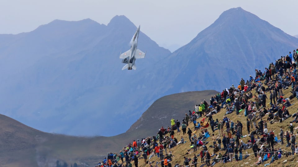 Ein Kampfflugzeug der Schweizer Luftwaffe fliegt vor Publikum auf der Axalp.  