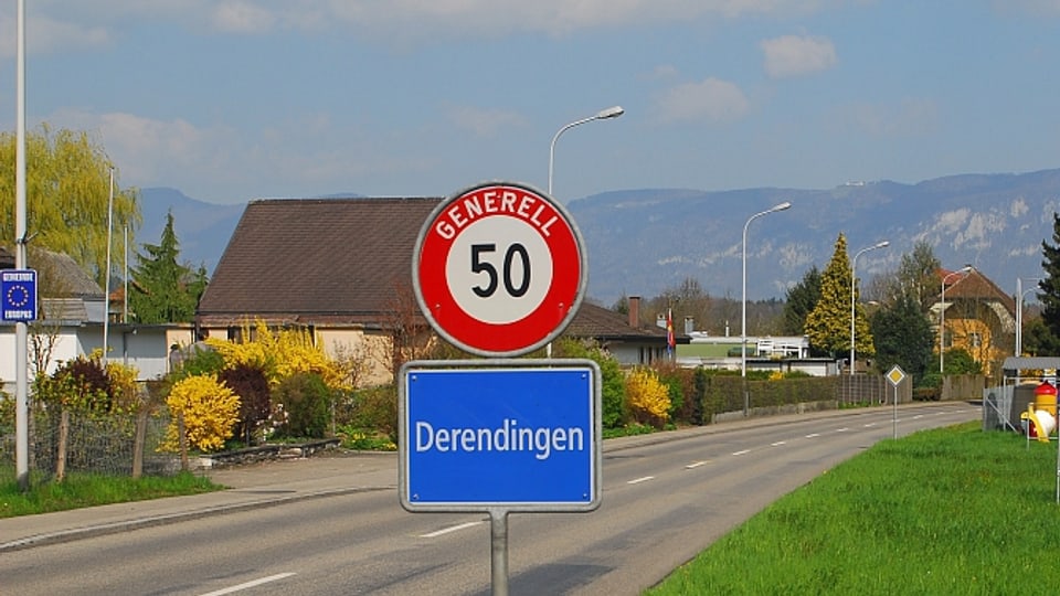 Ortstafel der Gemeinde Derendingen vor mehreren Häusern.