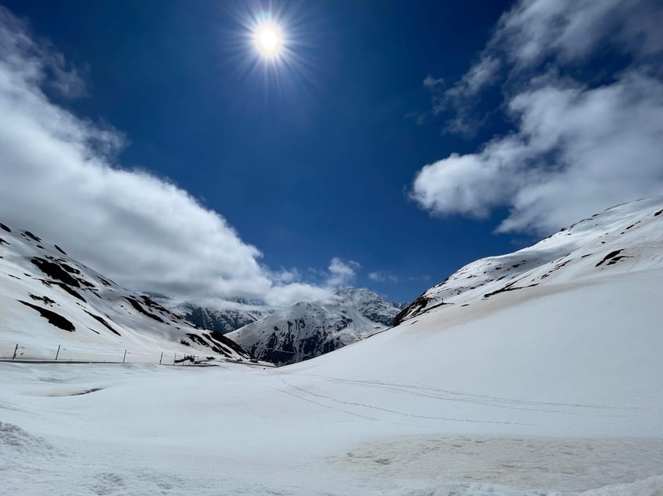 Alpental mit viel Schnee, Sonne und blauem Himmel mit wenigen Wolken