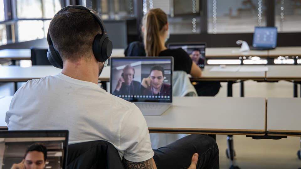 ... während ihre Kommilitoninnen und Kommilitonen die Interviews an ihren Laptops verfolgen.