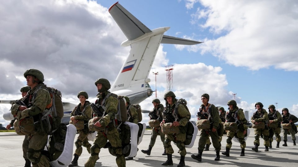Truppen marschieren auf einem Flugplatzgelände