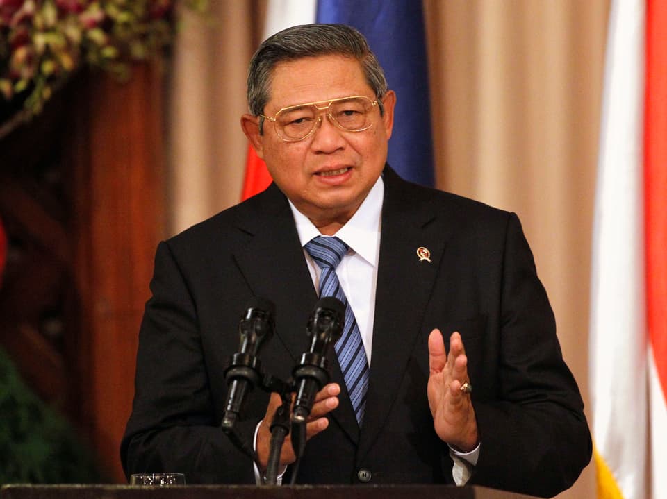 Susilo Bambang Yudhoyono steht in einem Anzug hinter Mikrofonen