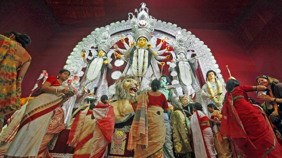 Frauen vor Statue der Göttin Durga