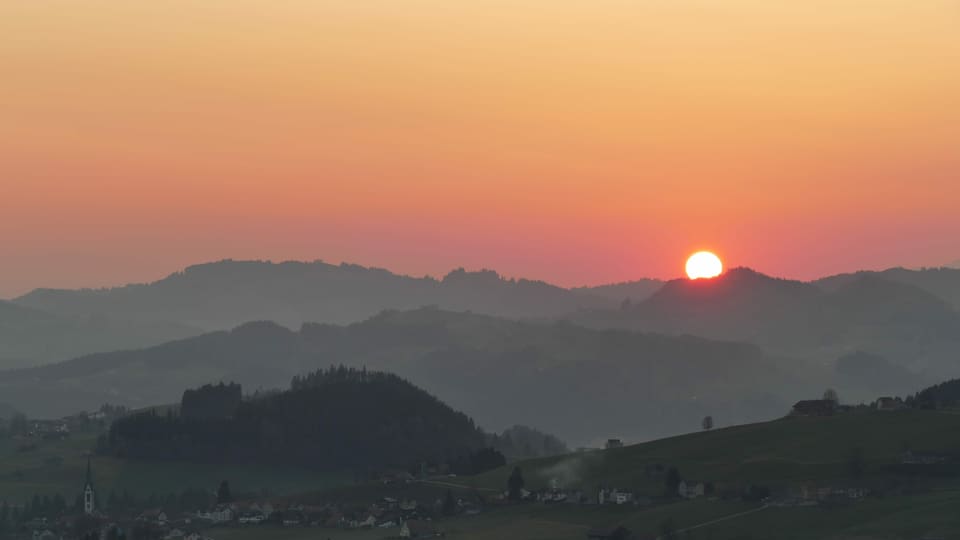 Die Sonne geht über den Hügelzügen des Appenzellerlandes auf.