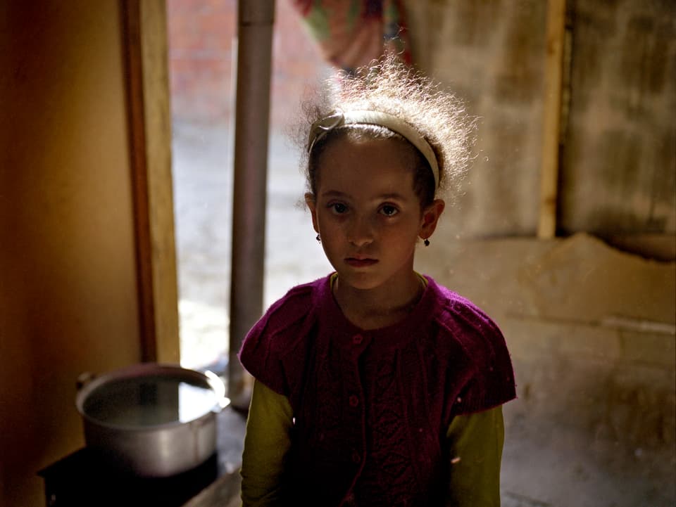 Ein aserbaidschanisches Mädchen im im Halbdunkel eines Hauses, Fotografie von Rena Effendi.