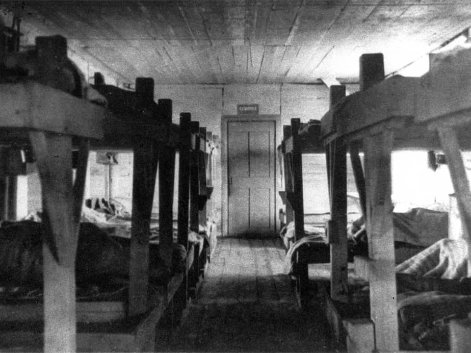 Schwarz-Weiss Bild eines Gulags von innen.