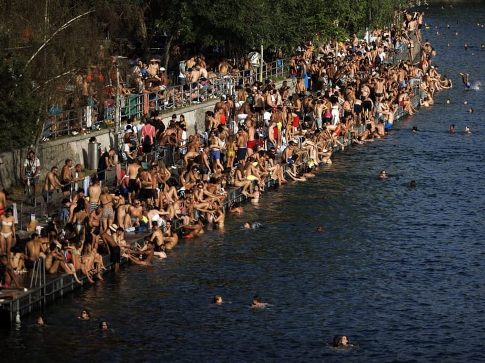 Dicht an dicht sitzen die Menschen am Samstag in Zürich an der Limmat.
