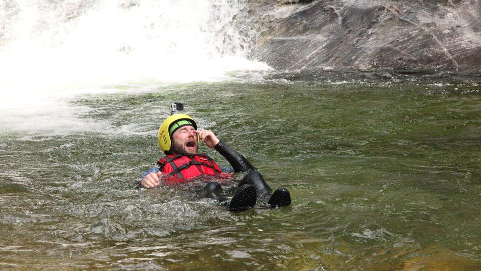 Nik treibt im Wasser am Fusse eines Wasserfalles. 