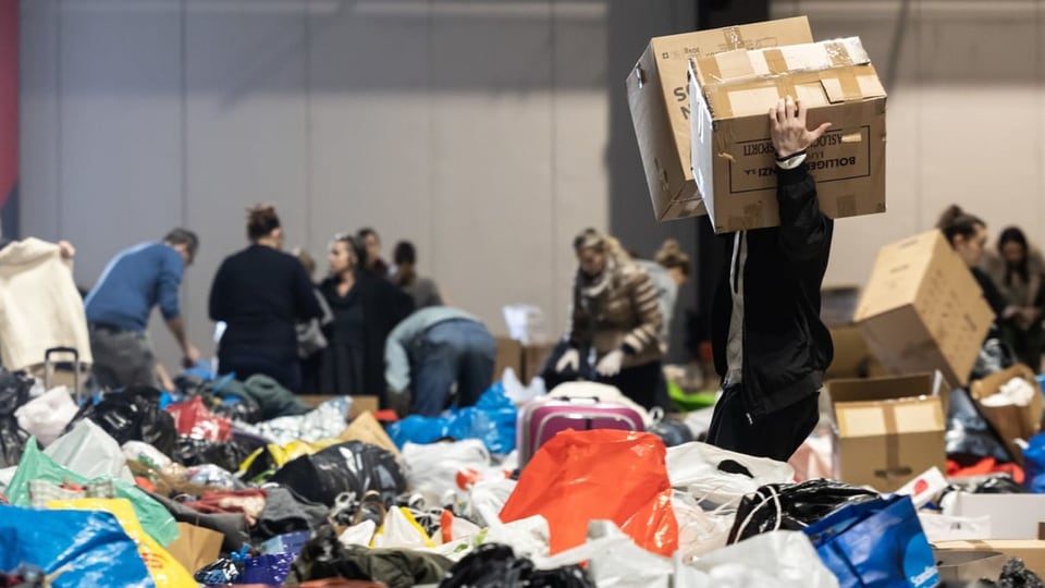 Mehrere Personen sortieren Hilfsgüter.