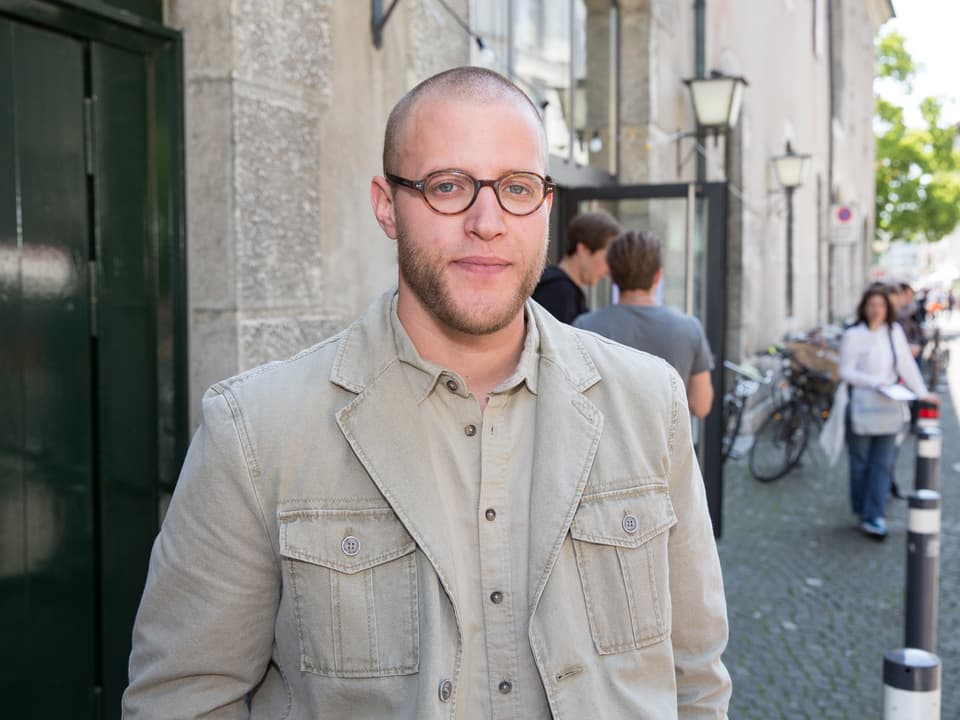 Adrian Hummer auf einer Strasse in Solothurn. Er trägt eine beige Jacke und Brille.