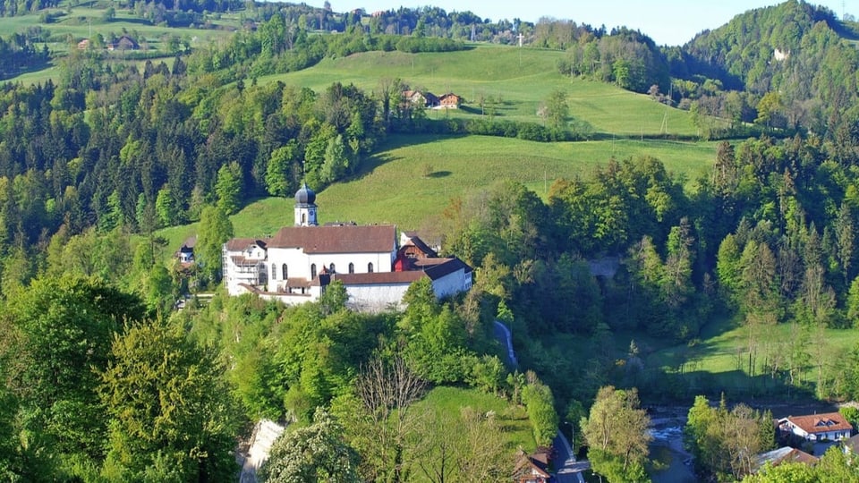 Eine Kapelle thront auf einem Hügel in grüner Napf-Landschaft.