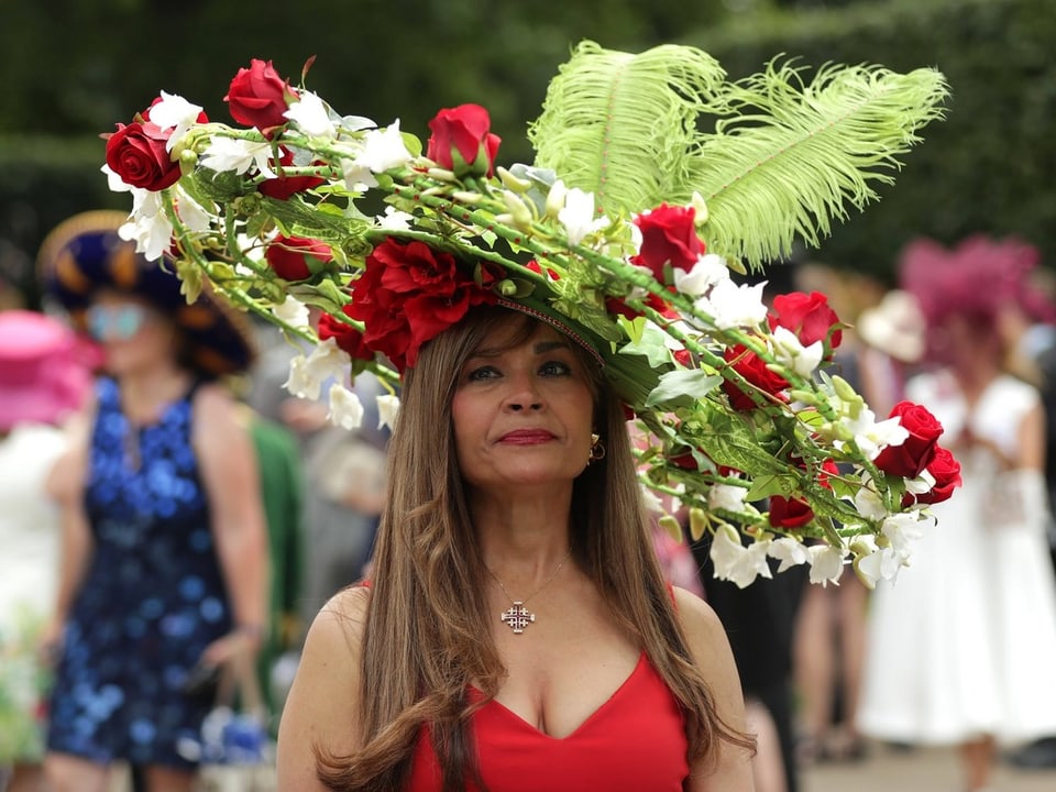 Eine Frau mit einem Hut, der an einen Blumenkranz aus Rosen erinnernt.
