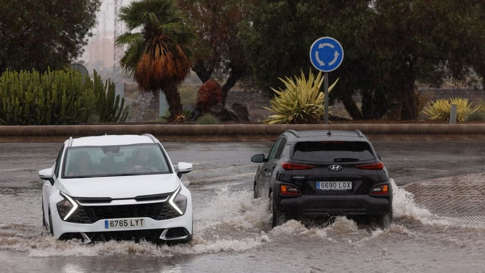 Zwei Autos, die auf einer überfluteten Strasse fahren