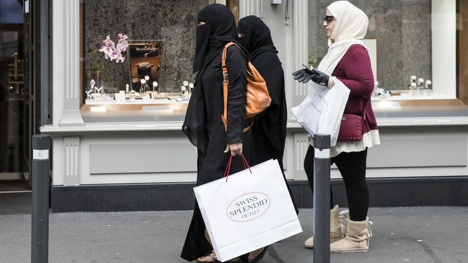 Drei Touristinnen, zwei davon mit Nikab, mit Einkaufstaschen