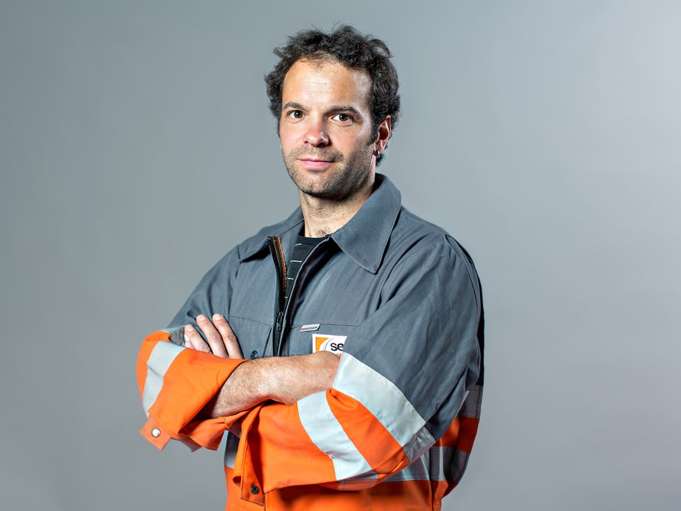 Mann in grau-oranger Arbeiterkluft.
