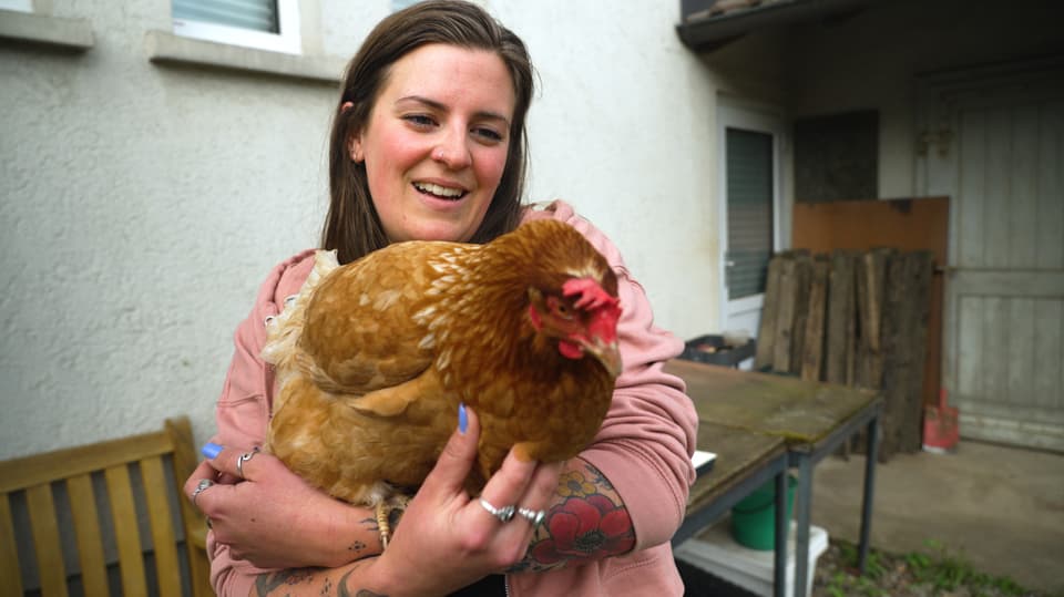 Tabea mit einem Huhn auf dem Arm.