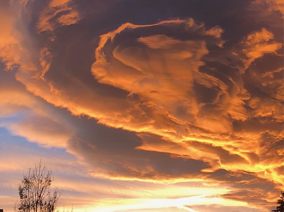 Verformte Wolkenform am Himmel bei rötlich-gelblicher Morgenstimmung.