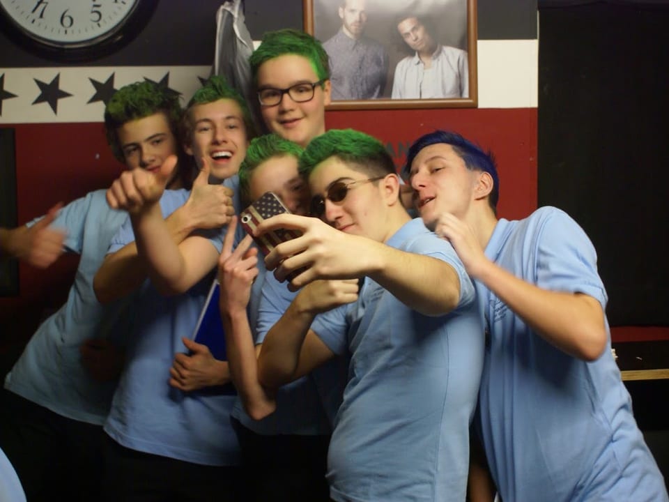 Mehrere Jungs posieren für ein Selfie mit ihren grün gefärbten Haaren.