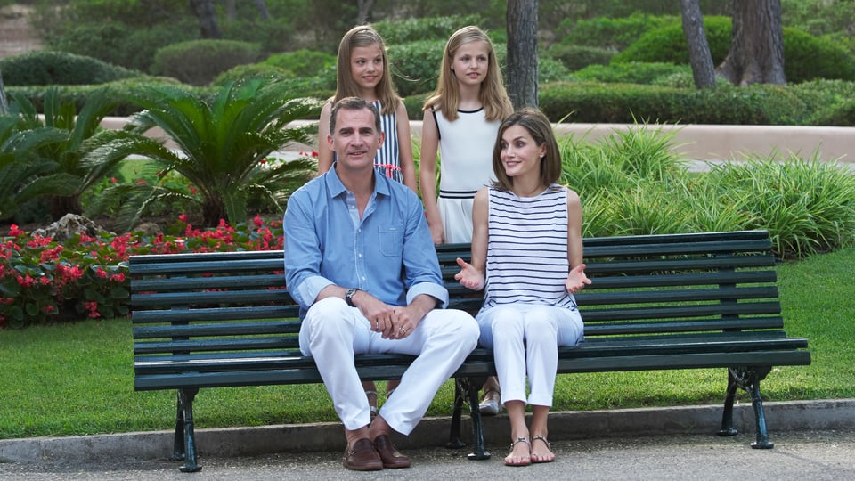 Das Königspaar sitzt auf einem Bank, dahinter stehen die Töchter.