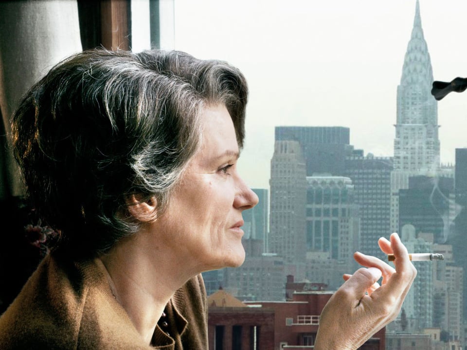 Hannah Arendt sitzt am Fenster und raucht eine Zigarette.