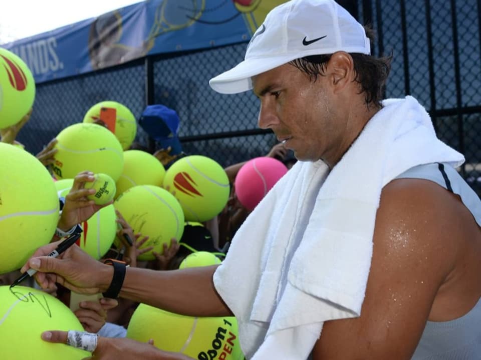Auf dem Bild ist Rafael Nadal zu sehen. Er gibt Unterschriften.