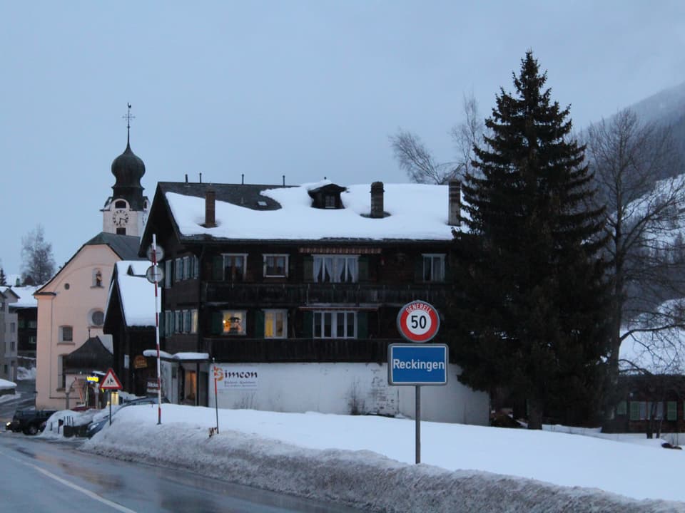 Dorfeingang von Reckingen mit Kirche und den ersten Häusern.