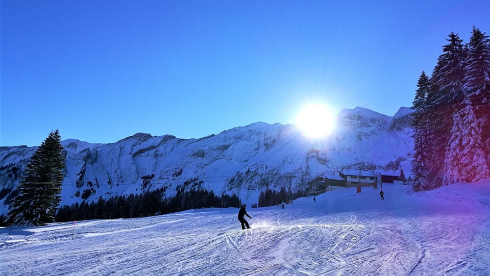 Skifahrer carvt in Sörenberg der Sonne entgegen.