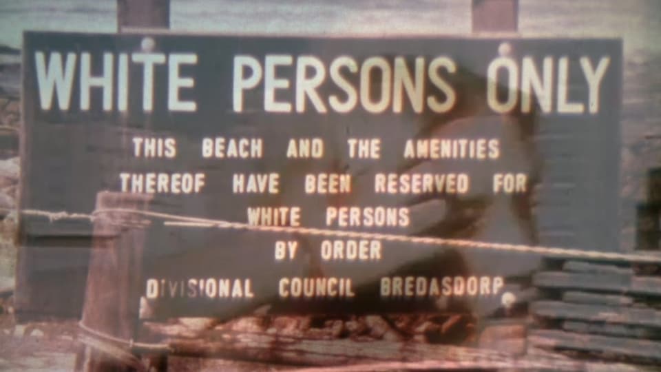 Foto mit Schild am Strand. Darauf steht: «White persons only».