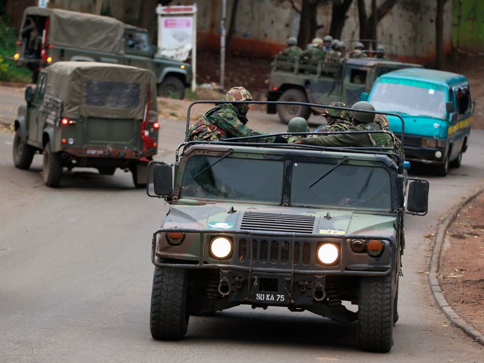Militärfahrzeuge mit Soldaten.