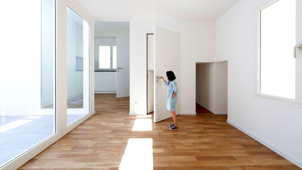 Eine Besucherin öffnet im Schweizer Pavillon eine überdimensionierte Tür.