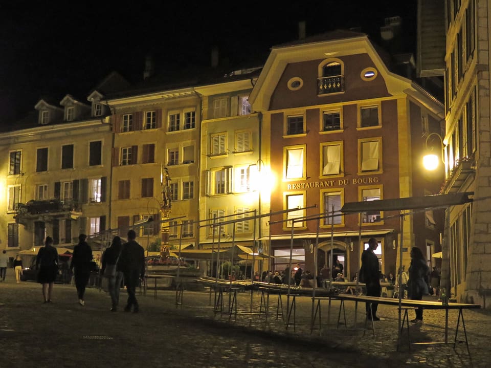 Altstadt bei Nacht, Tische sind aufgestapelt, Leute laufe weg