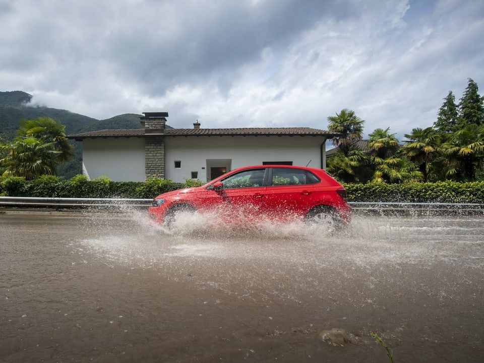 Autos fahren auf überschwemmten Strassen in Melano TI