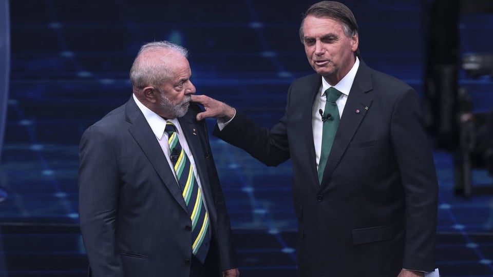 Bolsonaro legt seine Hand auf die Schulter Lulas, der sichtlich genervt zu sein scheint.