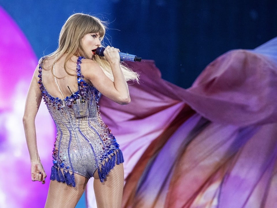 Taylor Swift performt auf der Bühne in einem glitzernden Body.
