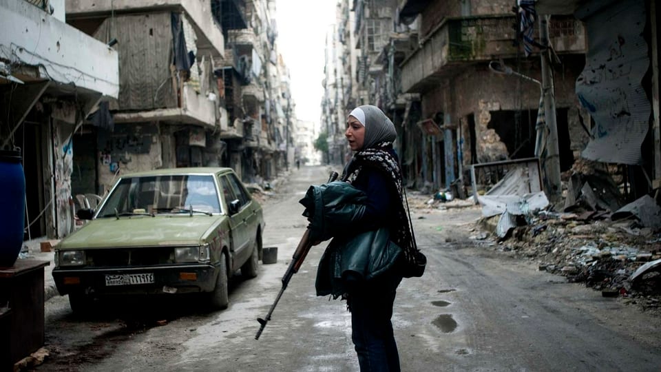 Eine Frau kämpft mit einem Gewehr gegen das syrische Regime.