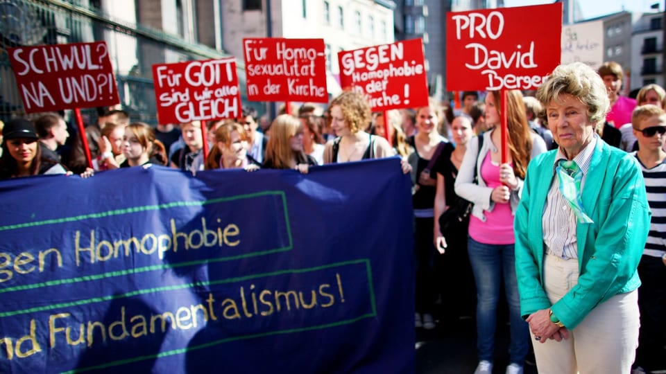 Junge Schülerinnen und eine ältere Frau an einer Demonstration