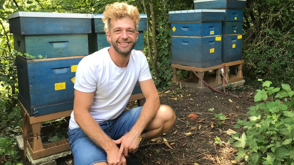 Ein blonder Mann hockt vor mehreren Bienenstöcken.