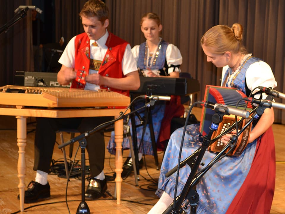 Junge Volksmusikanten mit Hackbrett, Piano und Schwyzerörgeli.