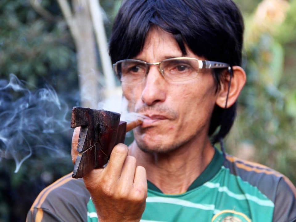 Werás Vater Olivio pafft an einer selbstgeschnitzten Tabakpfeife.