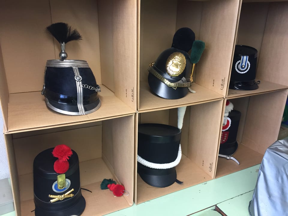 Alte Armee-Hüte mit entsprechenden Emblemen und Abzeichen