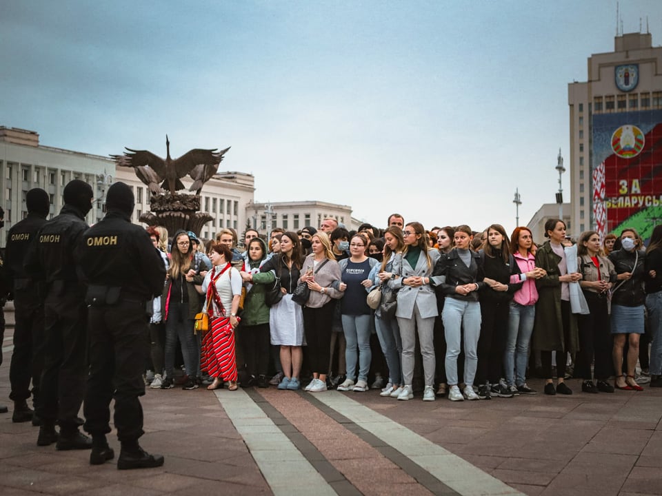 Eine friedliche Gruppe von Frauen steht vor einer Reihe Polizisten